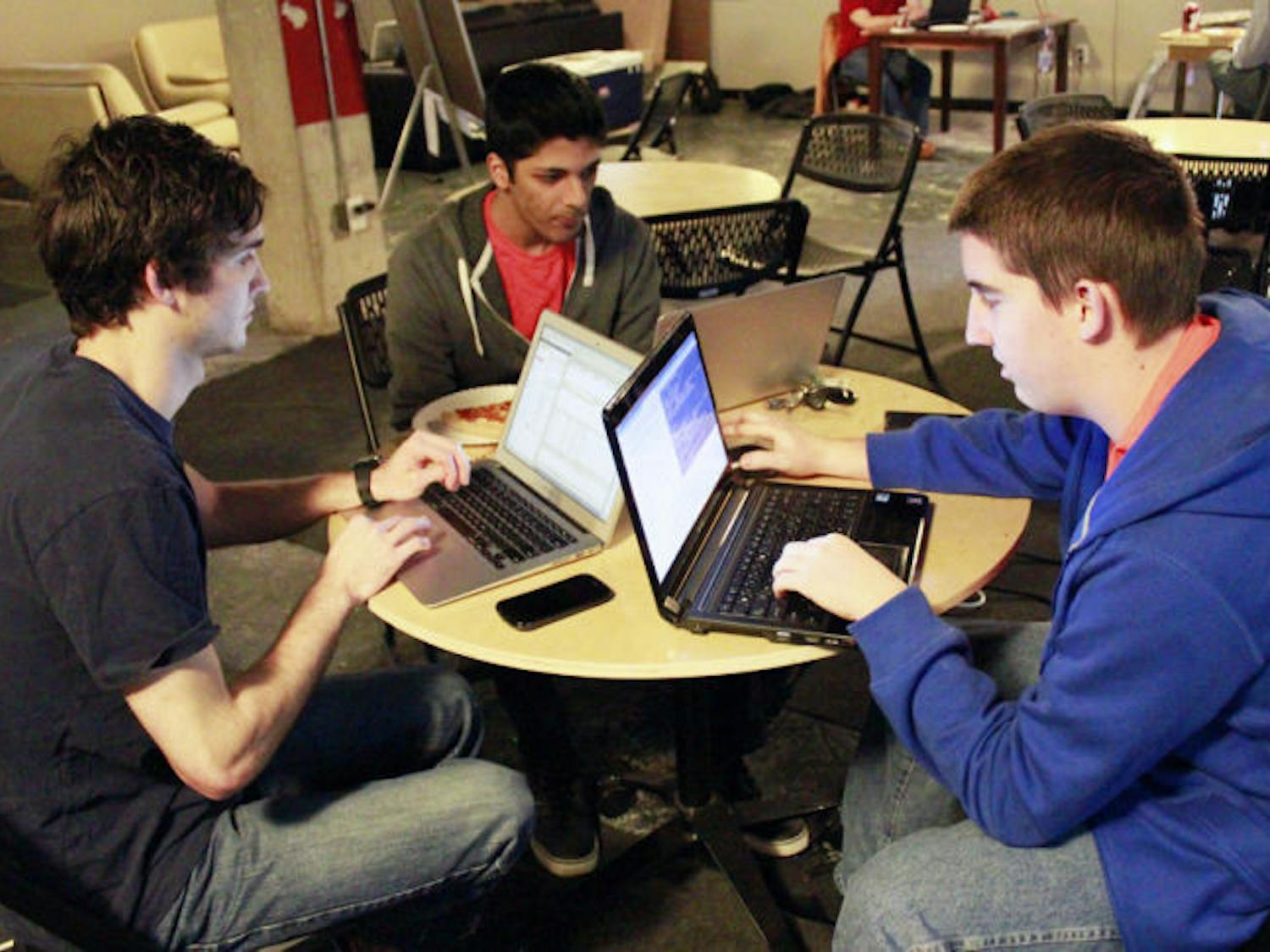 Joe Furlott, 20, Shyamal Patel, 21, and Derek Brown, 21, a group of UF computer sciences juniors work on an Android application during Hackathon, a 24-hour event at Hackerspace on Saturday. Participants worked for a shot to win $500.
