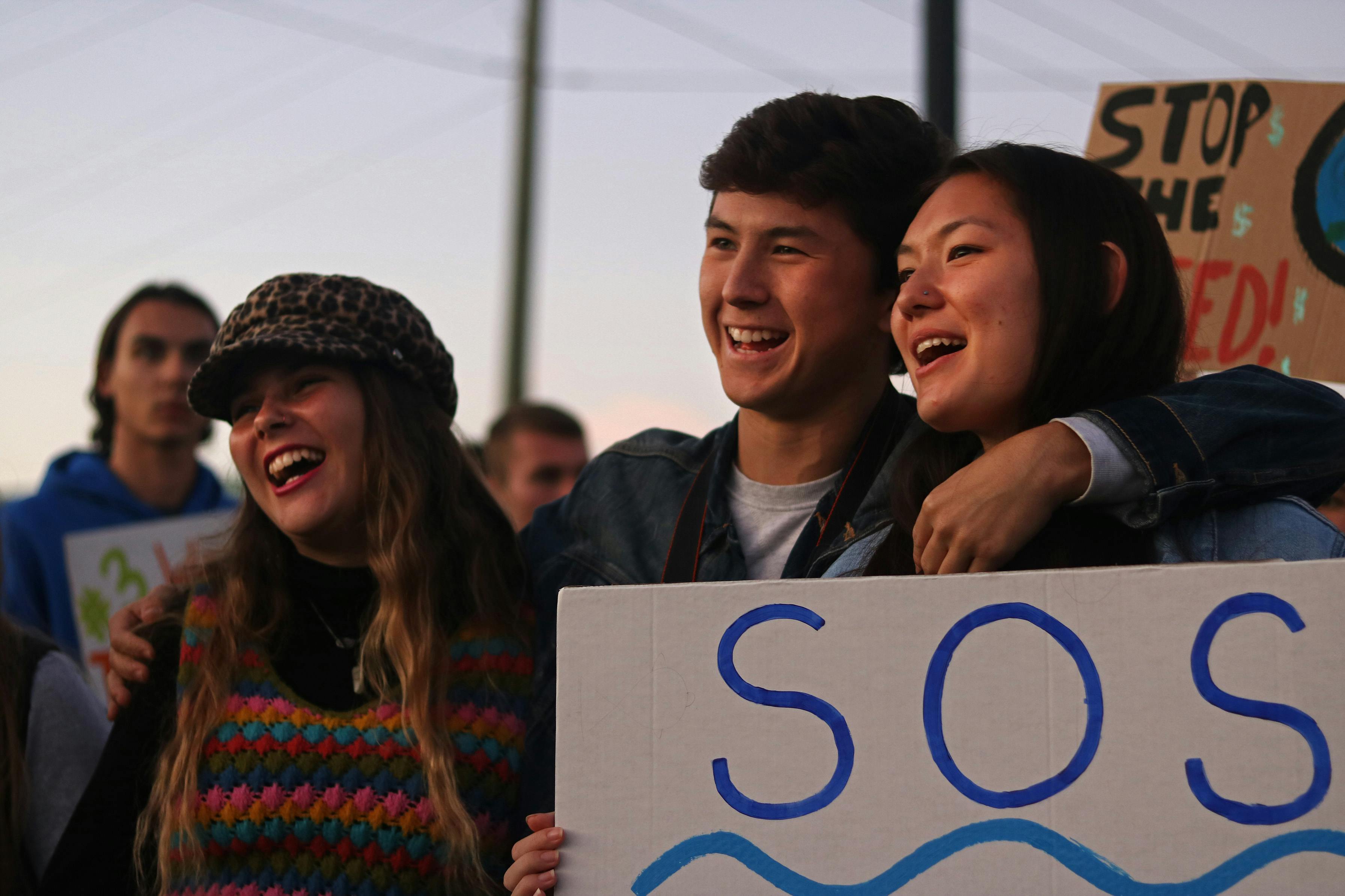 Jovanna Liuzzo, an 18-year-old UF political science freshman, Gaven Simon, a 19-year-old UF sustainability senior, and Kathryn Kuchman, a 19-year-old UF psychology sophomore, sing along to protest songs during the rally against Nestlé Friday in High Springs. The three students attended as members of the activist organization Climate Action Gators. 