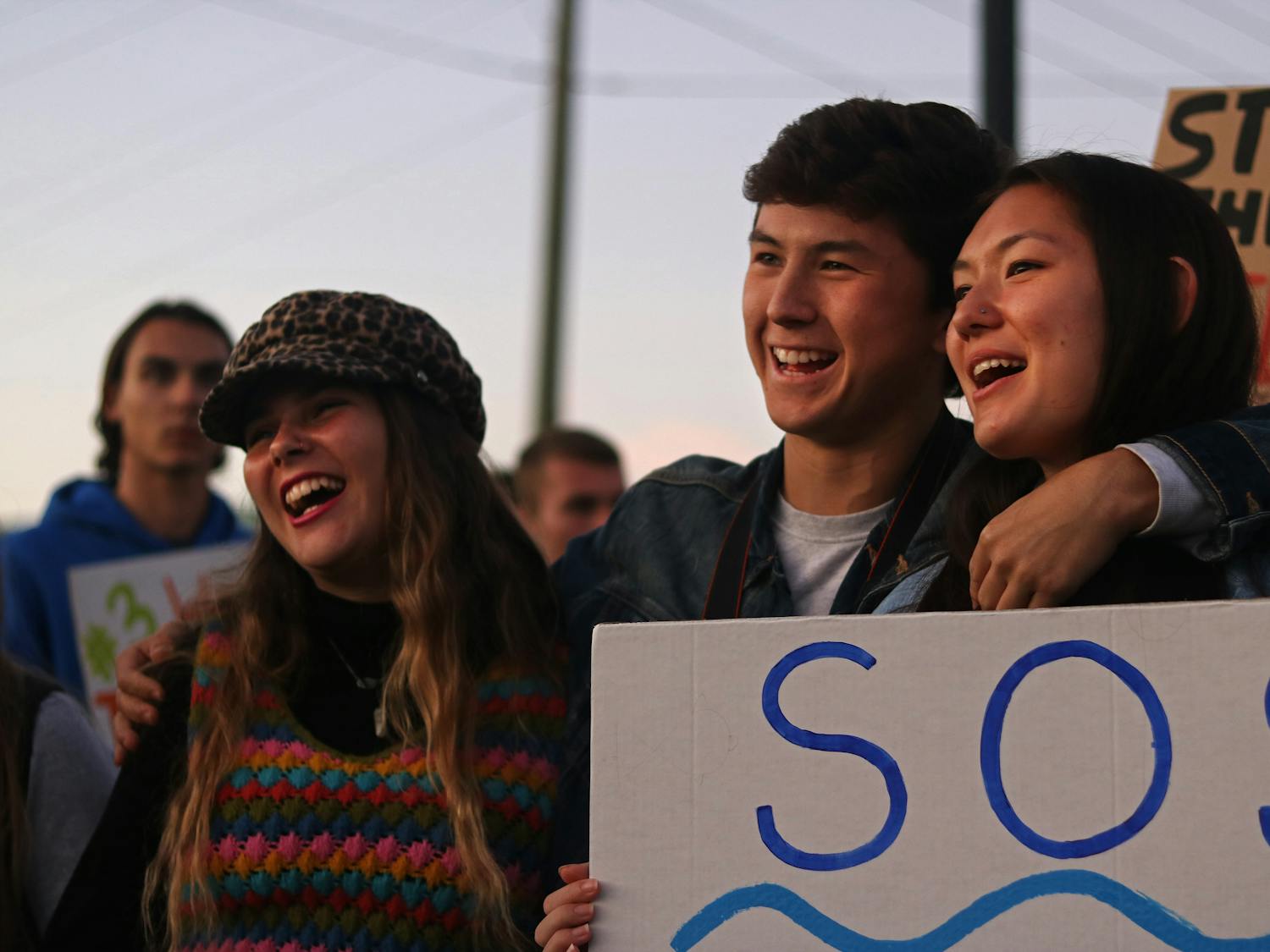 Jovanna Liuzzo, an 18-year-old UF political science freshman, Gaven Simon, a 19-year-old UF sustainability senior, and Kathryn Kuchman, a 19-year-old UF psychology sophomore, sing along to protest songs during the rally against Nestlé Friday in High Springs. The three students attended as members of the activist organization Climate Action Gators.