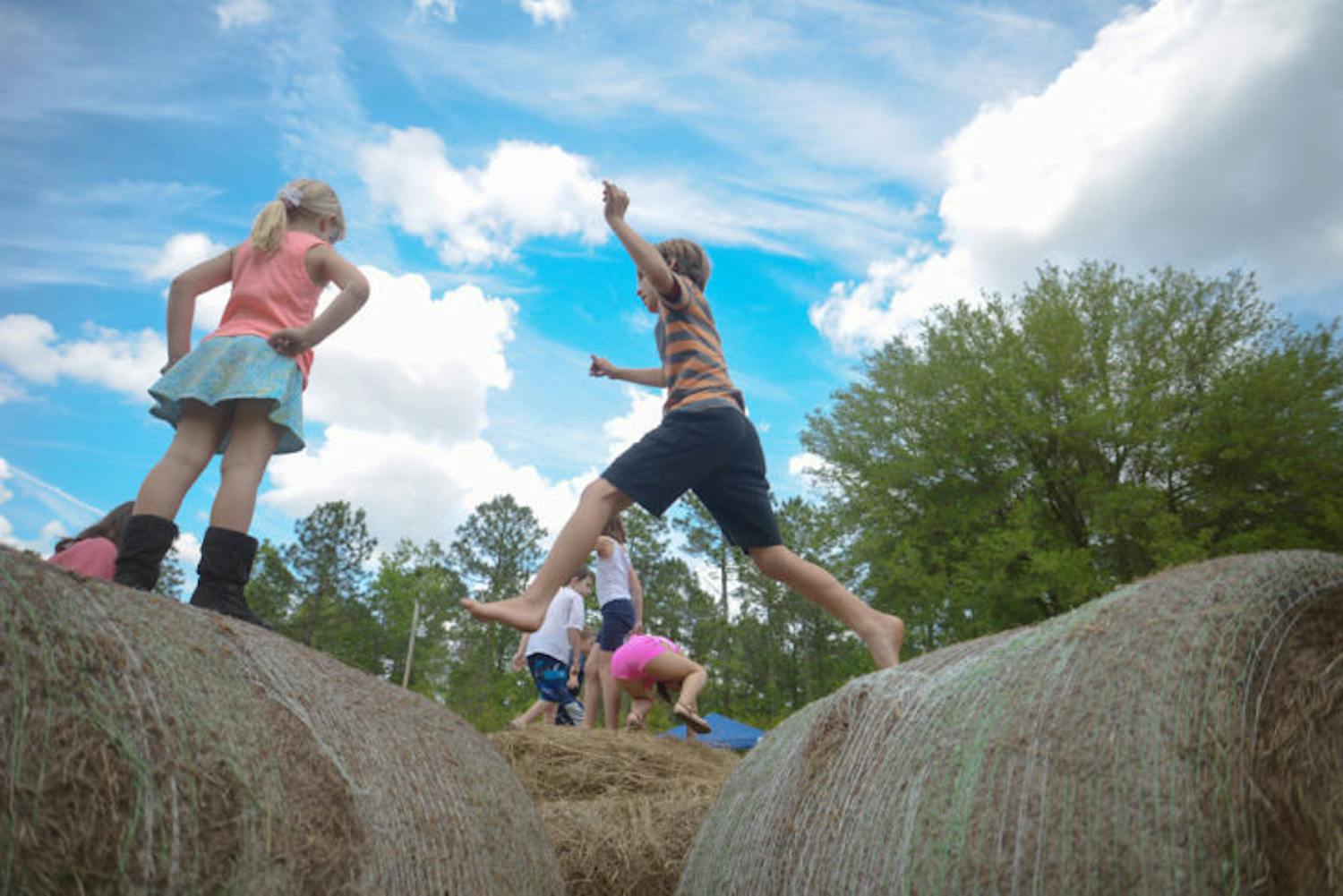 Kids play on hay bales at the fifth annual Swallowtail Country Fair on Saturday. The event, hosted at Swallowtail Farm north of Alachua, featured music, kids activities, workshops and demonstrations.