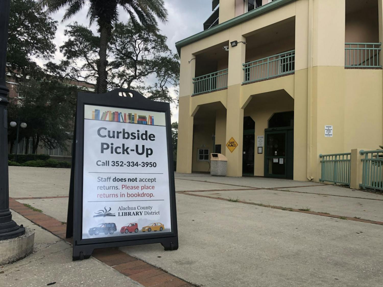 Signs outside of the Headquarters Branch of the Alachua County Library District direct patrons interested in curbside service.