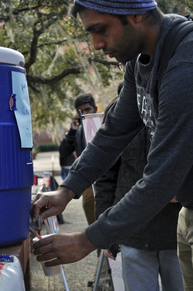 Devesh Amin, a 20-year-old UF microbiology sophomore, pours hot chocolate into a disposable cup at a Gator Wesley tabling event on Turlington Plaza on Thursday afternoon.