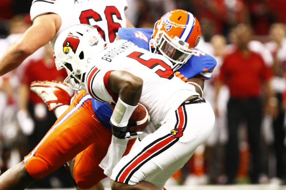 <p class="p1">Florida defensive tackle Damien Jacobs tackles Louisville quarterback Teddy Bridgewater (5) during the Gators’ 33-23 loss to the Cardinals on Jan. 2 at the Superdome in New Orleans.</p>