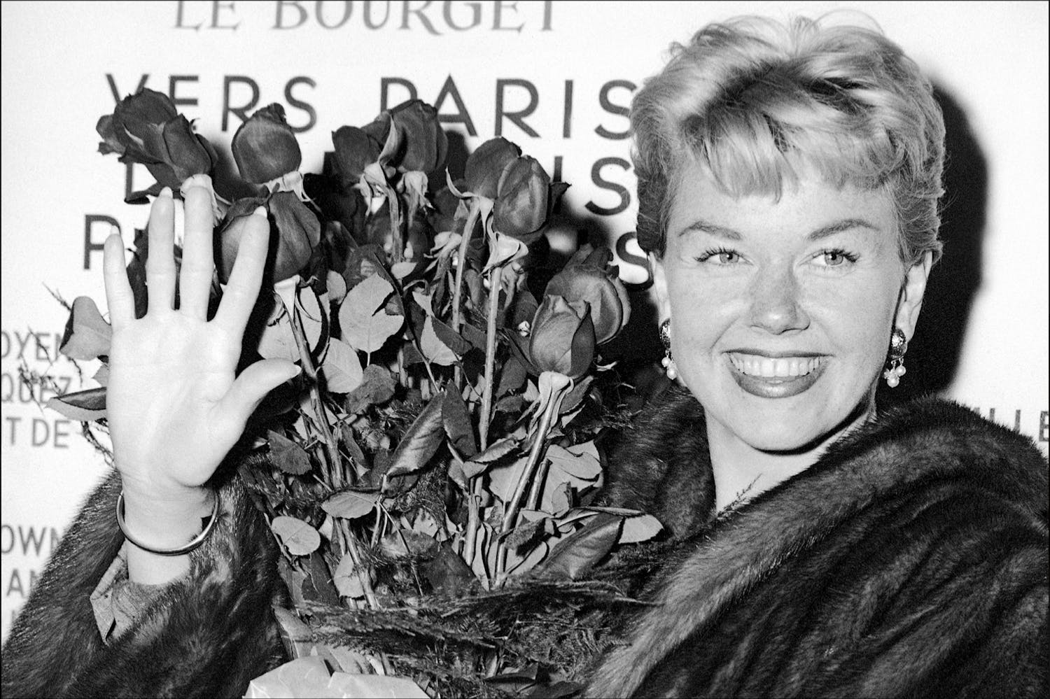 In this April 15, 1955, file photo, American actress and singer Doris Day holds a bouquet of roses at Le Bourget Airport in Paris after flying in from London. The Doris Day Animal Foundation confirmed Day died early Monday, May 13, 2019, at her home in Carmel Valley, Calif. She was 97.