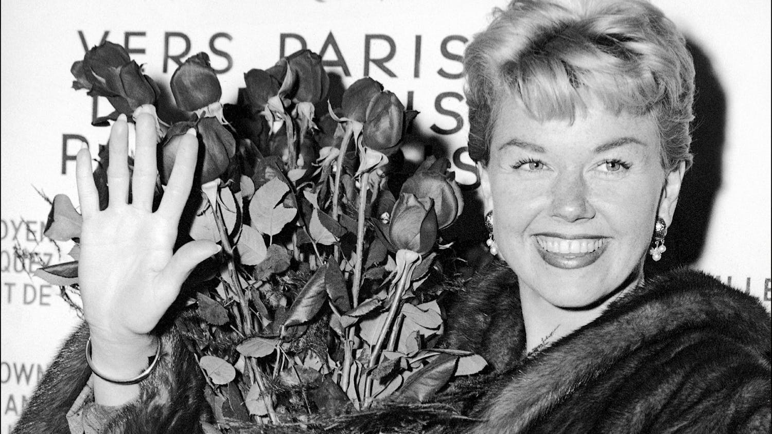 In this April 15, 1955, file photo, American actress and singer Doris Day holds a bouquet of roses at Le Bourget Airport in Paris after flying in from London. The Doris Day Animal Foundation confirmed Day died early Monday, May 13, 2019, at her home in Carmel Valley, Calif. She was 97.