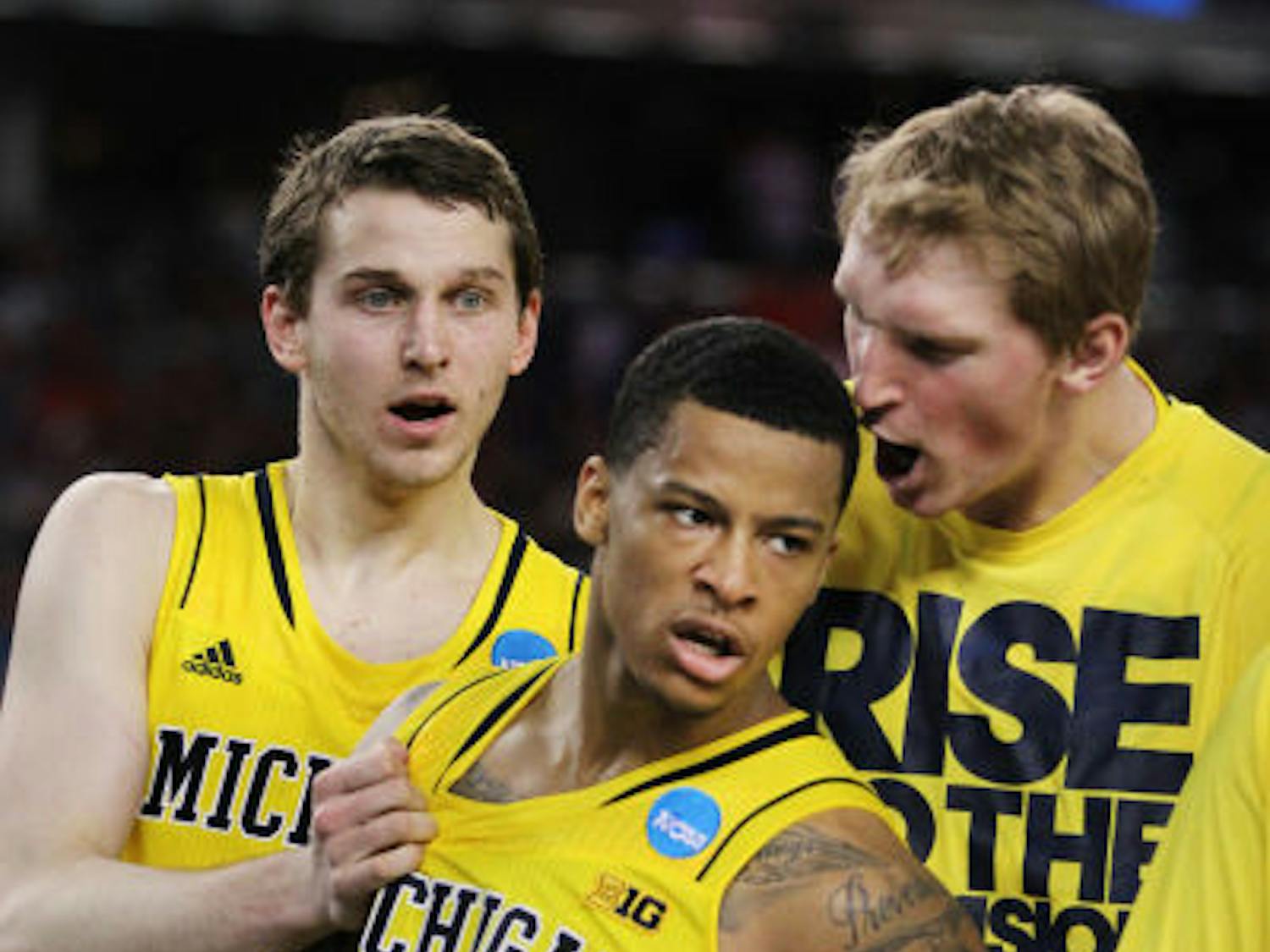 Guard Trey Burke (3) celebrates with his teammates during Michigan’s 87-85 overtime win against Kansas on March 29 in Arlington, Texas.