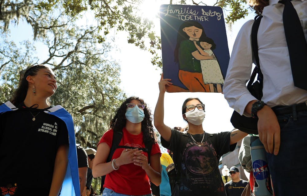A protester holds a sign reading “Families belong together” during a Young Democratic Socialists of America protest in Turlington Plaza against the University of Florida’s decision to partner with ICE on Wednesday, Nov. 5, 2025.
