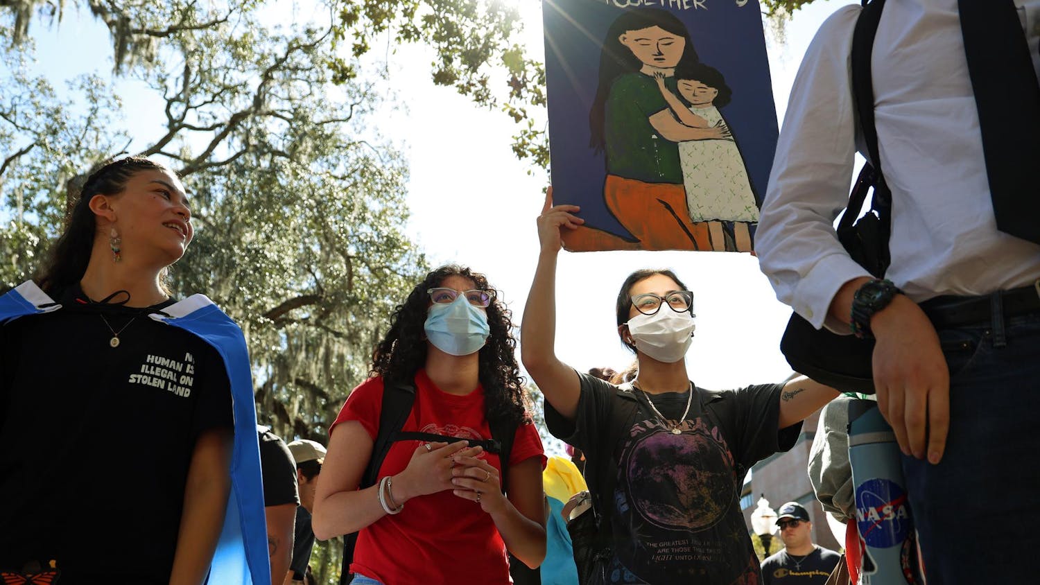 A protester holds a sign reading “Families belong together” during a Young Democratic Socialists of America protest in Turlington Plaza against the University of Florida’s decision to partner with ICE on Wednesday, Nov. 5, 2025.