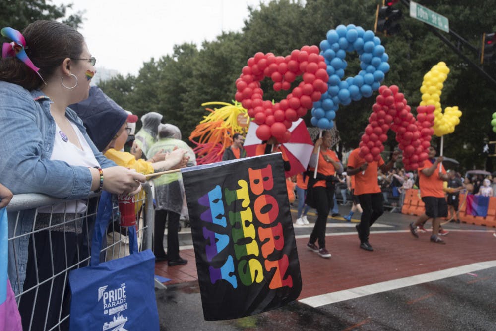 Jessica Cramblett, 27, from Dahlonega, Ga., who identifies as pansexual, holds a "Born This Way" flag as she watches the city's annual Gay Pride parade on Sunday, Oct. 13, 2019, in Atlanta. (AP Photo/ Robin Rayne)