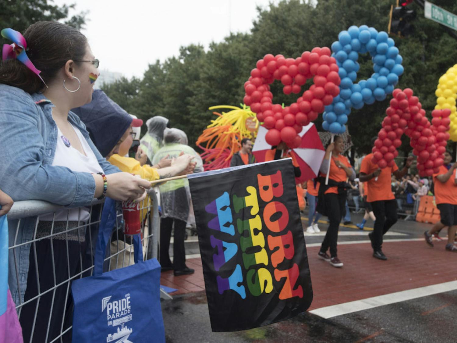 Jessica Cramblett, 27, from Dahlonega, Ga., who identifies as pansexual, holds a "Born This Way" flag as she watches the city's annual Gay Pride parade on Sunday, Oct. 13, 2019, in Atlanta. (AP Photo/ Robin Rayne)