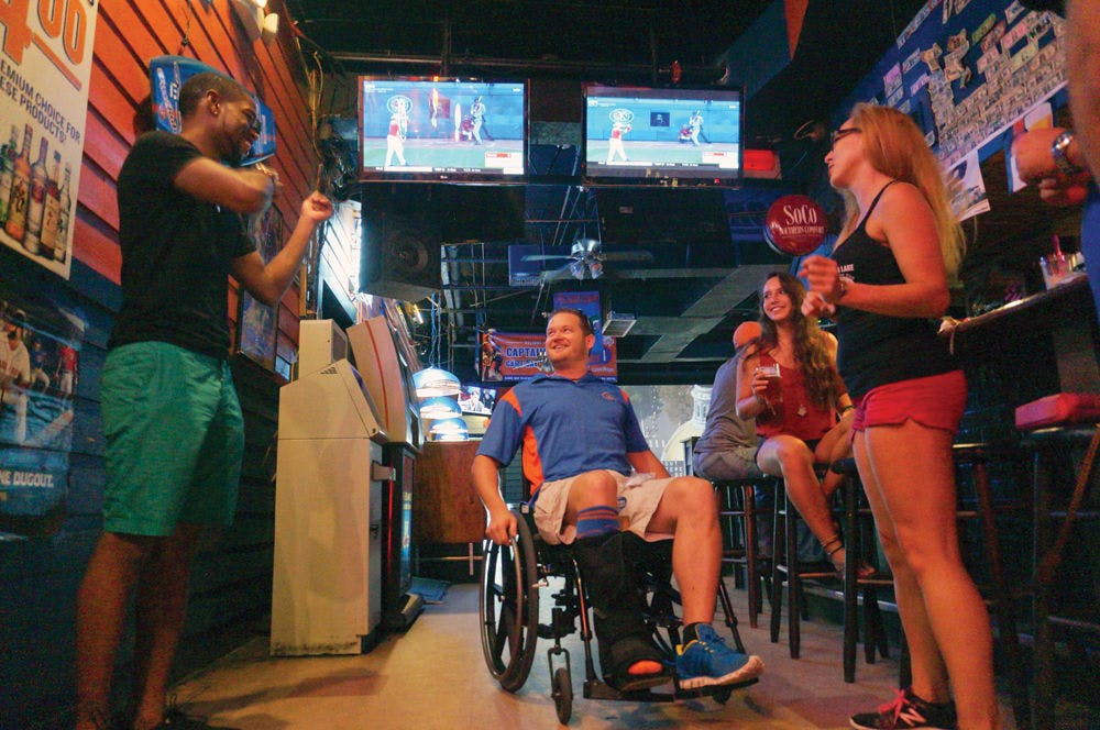Brad Heron, piano player and owner at Rockey's Dueling Piano Bar, spent Sunday night out with his coworkers Sean Reed (left), Mayan Alvarado (middle) and Marylin Prado (right). He is one of 30 people who will participate in the Wheelchaired for a Day Challenge in Gainesville this month, which raises awareness of issues that affect the disabled community.