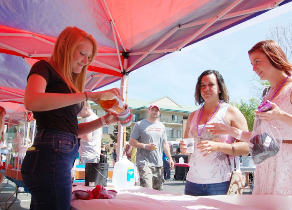 <p class="p1">Emily Headrick, left, pours a patron a beer Saturday at the Burkhardt tent. Hundreds of beer lovers attended the 17th Greater Gator Beer Festival at Magnolia Park and received unlimited 2-ounce pours and food with admission. The festival almost didn’t happen this year due to late approval by the city.</p>