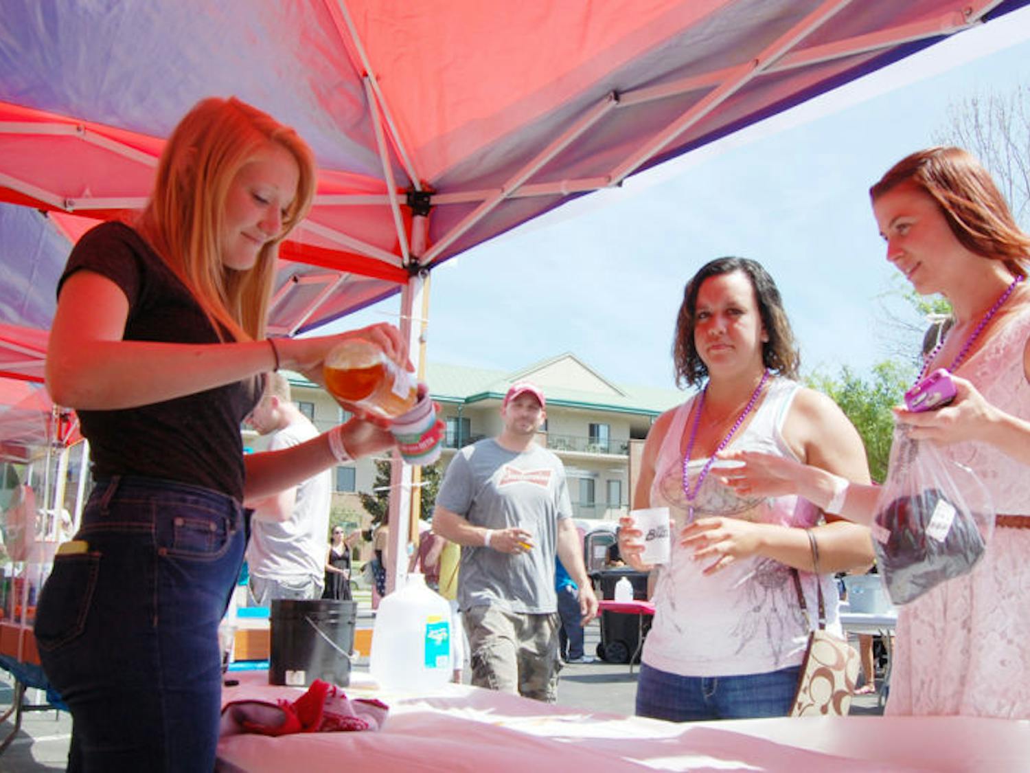 Emily Headrick, left, pours a patron a beer Saturday at the Burkhardt tent. Hundreds of beer lovers attended the 17th Greater Gator Beer Festival at Magnolia Park and received unlimited 2-ounce pours and food with admission. The festival almost didn’t happen this year due to late approval by the city.
