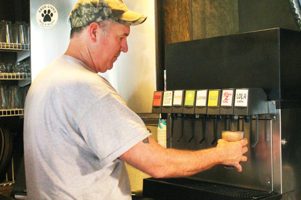 <p>Satchel Raye, owner of Satchel’s Pizza, prepares a zero-calorie, stevia-sweetened drink, Stevie Z Cal, on Wednesday afternoon.</p>
