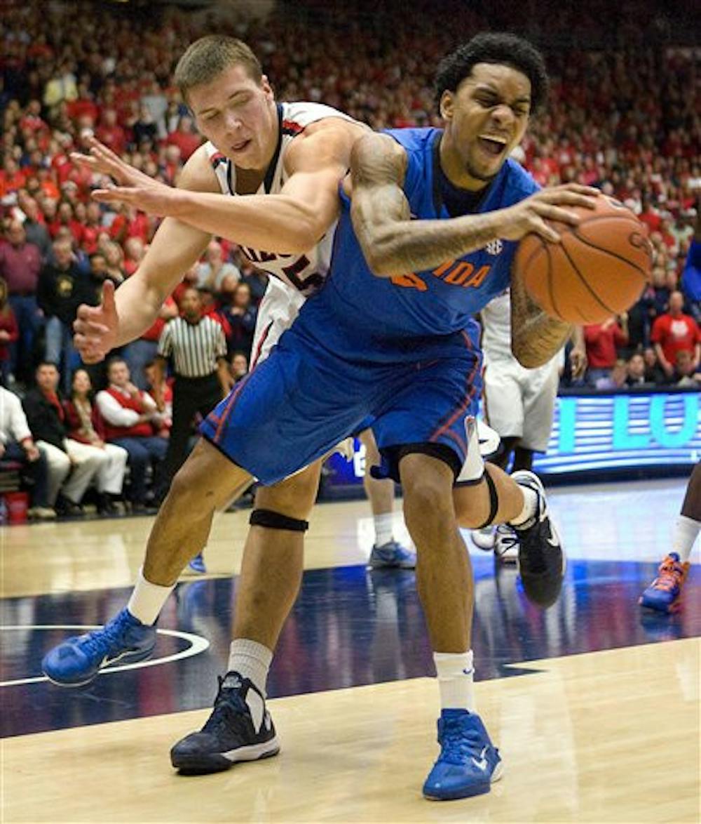 <p>Florida's Mike Rosario (3) takes the ball away from Arizona's Kaleb Tarczewski (35) during the first half of an NCAA college basketball game at McKale Center on Saturday night in Tucson, Ariz. No. 8 Arizona defeated No. 5 Florida 65-64 by finishing the game on a 7-0 run.</p>