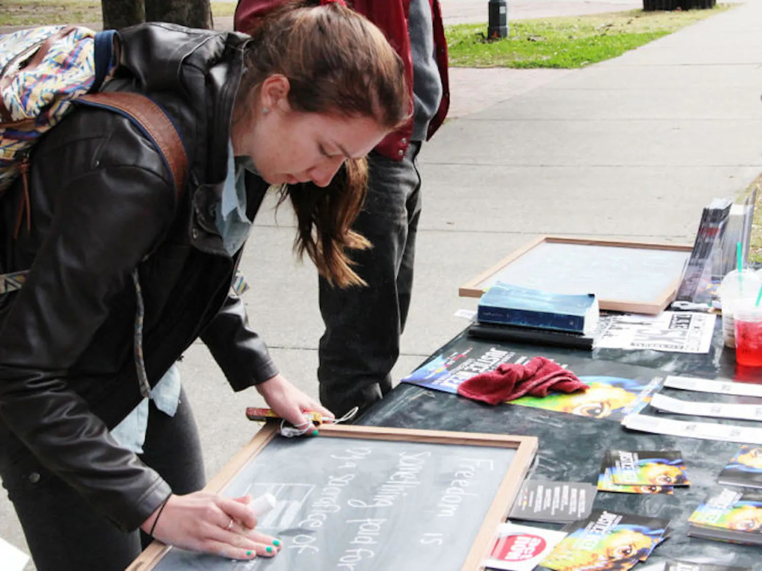 Jessica Forbes, 19, a UF applied physiology and kinesiology freshman, writes on a board at a demonstration fighting against human trafficking during Justice Week on Monday on Plaza of the Americas.