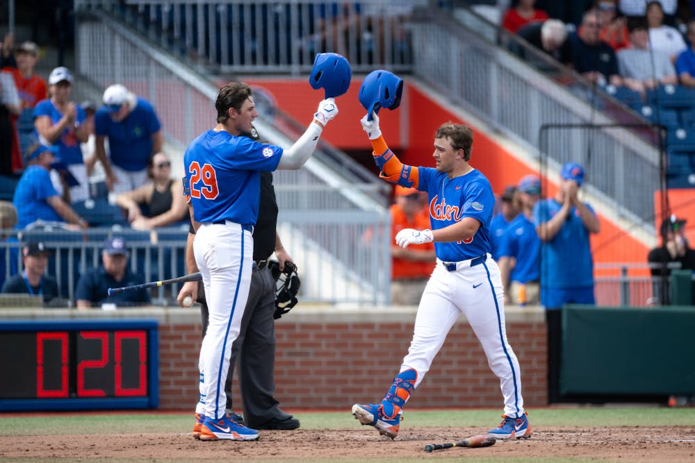 Florida Gators infielder Landon Stripling (13) helmet taps with teammate Brody Donay (29) after hitting his first home run of the season.