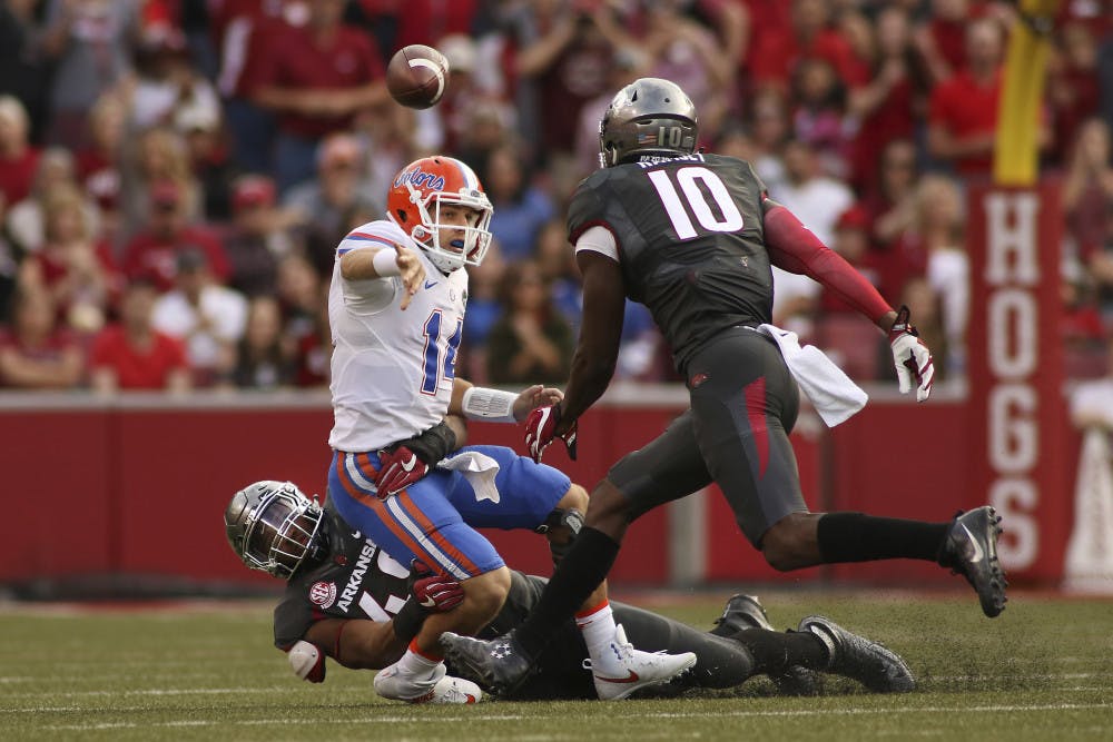 Florida's Luke Del Rio (14) looses the ball before being taken down by Arkansas' Deatrich Wise Jr. (48) and Randy Ramsey (10) during the second half of an NCAA college football game on Nov. 5, 2016 in Fayetteville, Arkansas. Arkansas beat Florida 31-10. (AP Photo/Samantha Baker)