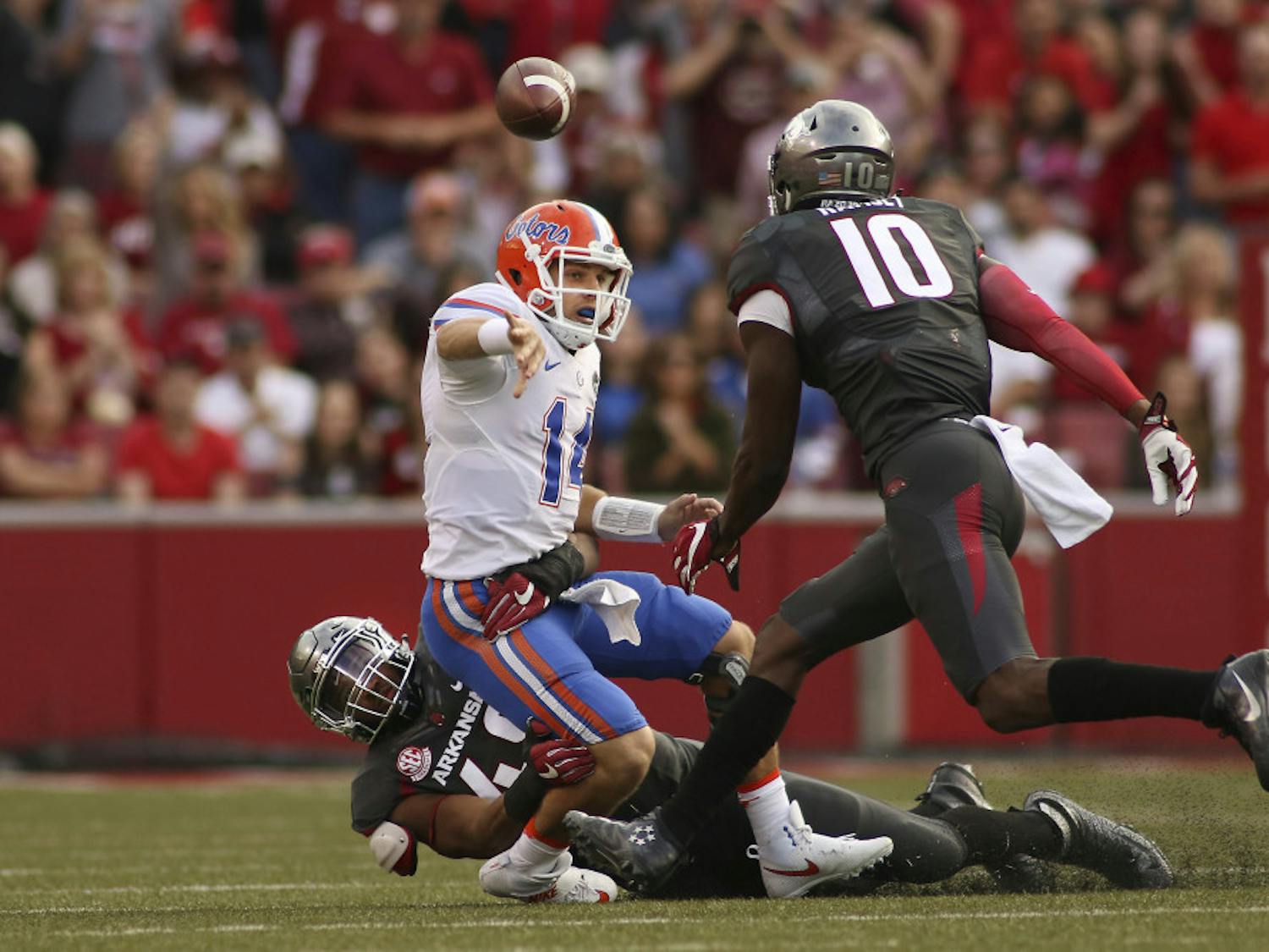 Florida's Luke Del Rio (14) looses the ball before being taken down by Arkansas' Deatrich Wise Jr. (48) and Randy Ramsey (10) during the second half of an NCAA college football game on Nov. 5, 2016 in Fayetteville, Arkansas. Arkansas beat Florida 31-10. (AP Photo/Samantha Baker)