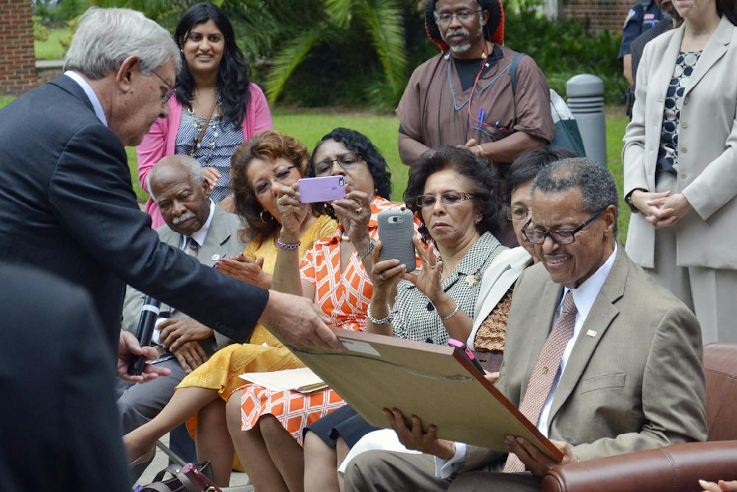 Judge Stephan P. Mickle, the first African-American to get a bachelor’s degree from UF and the second to graduate from UF’s Levin College of Law, smiles as he receives a plaque from George Dawson, the law school’s interim dean, during a tree dedication ceremony in 2015. About 75 people attended the ceremony on the UF Law West Courtyard.