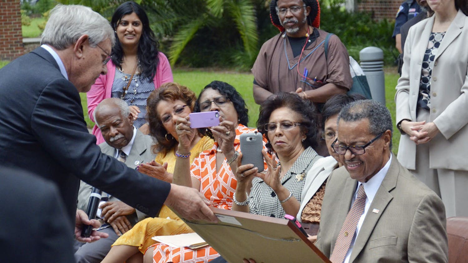 Judge Stephan P. Mickle, the first African-American to get a bachelor’s degree from UF and the second to graduate from UF’s Levin College of Law, smiles as he receives a plaque from George Dawson, the law school’s interim dean, during a tree dedication ceremony in 2015. About 75 people attended the ceremony on the UF Law West Courtyard.