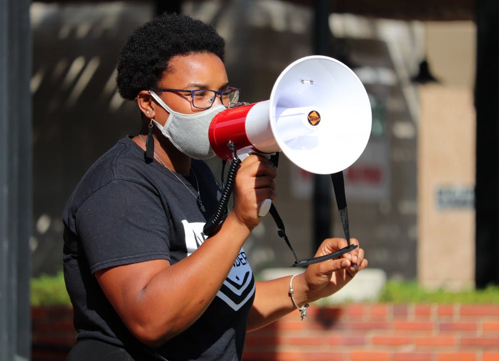 <p>Kiara Laurent speaks to the crowd at Bo Diddley Plaza in Gainesville before protesters march to the Alachua County Courthouse on Saturday, Sept. 26, 2020. Laurent is a member of the Dream Defenders, a black-led organization of young people who planned this event. (Lauren Witte/Alligator Staff)</p>