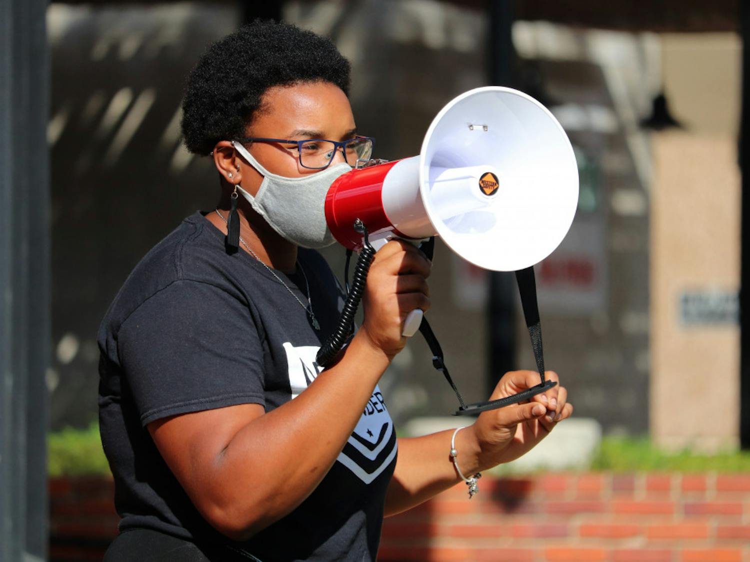 Kiara Laurent speaks to the crowd at Bo Diddley Plaza in Gainesville before protesters march to the Alachua County Courthouse on Saturday, Sept. 26, 2020. Laurent is a member of the Dream Defenders, a black-led organization of young people who planned this event. (Lauren Witte/Alligator Staff)