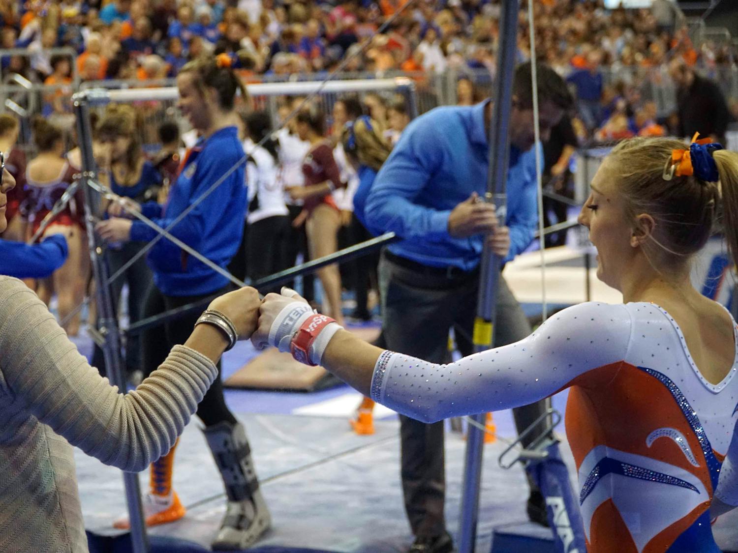 Coach Jenny Rowland fist-bumps gymnast Alex McMurtry prior to McMurtry’s uneven parallel bars during Florida’s win against Alabama on Jan. 29, 2016, in the O’Connell Center.