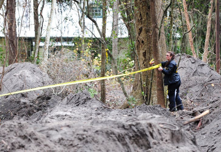 An ASO Forensics Unit investigator tapes off a dig site Thursday where a team searched for the remains of Tiffany Sessions, who went missing 25 years ago in Gainesville.