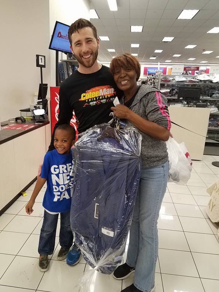 Eric Gilbert, a co-founder of Remedium, poses with a Burlington Coat Factory customer and her son. Gilbert, 34, paid for a men’s suit the woman had on layaway — a Christmas present for her husband.