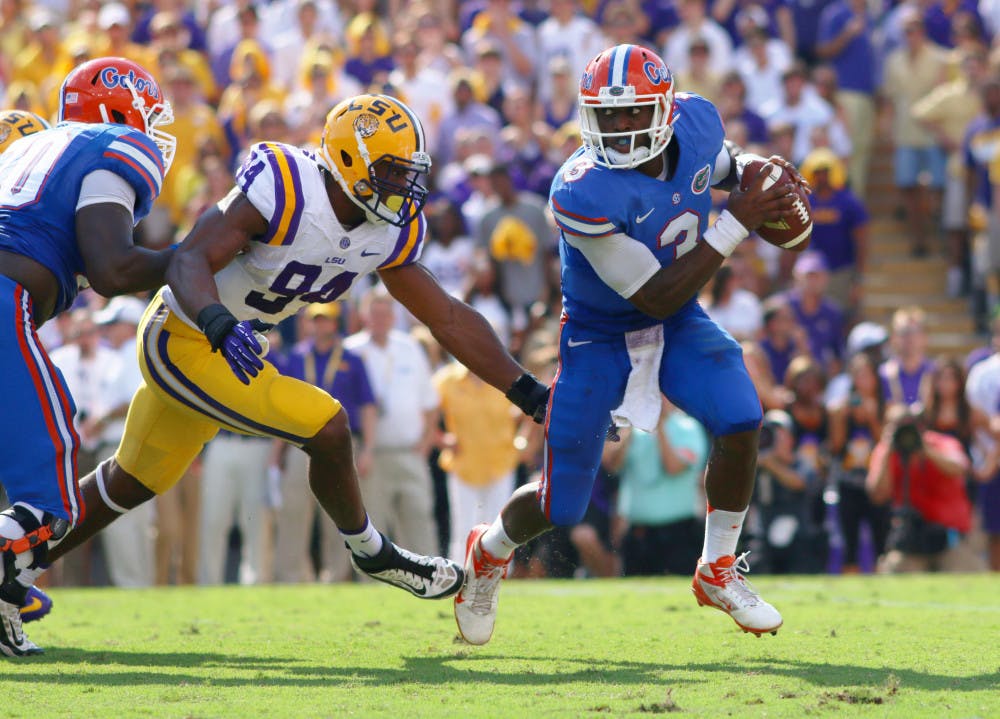 <p>Tyler Murphy (right) scrambles away from an LSU defensive lineman during Florida’s 17-6 loss on Saturday at Tiger Stadium in Baton Rouge, La. Murphy was sacked four times in the game for a loss of 40 yards.</p>