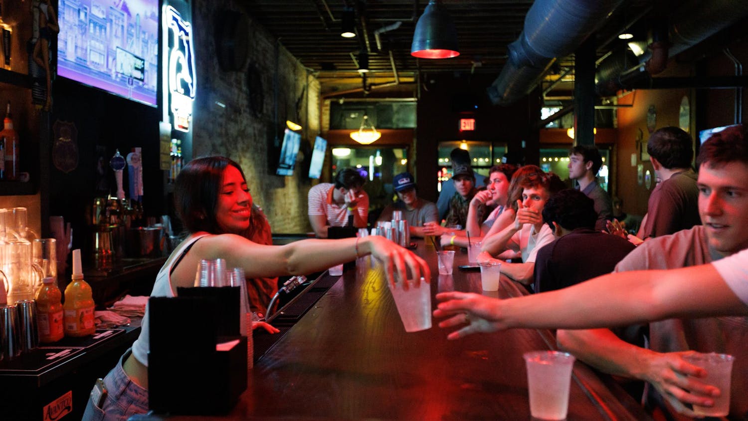 A bartender hands a drink to a patron at Whoopi's, Friday, March 6, 2026, in Gainesville, Fla.