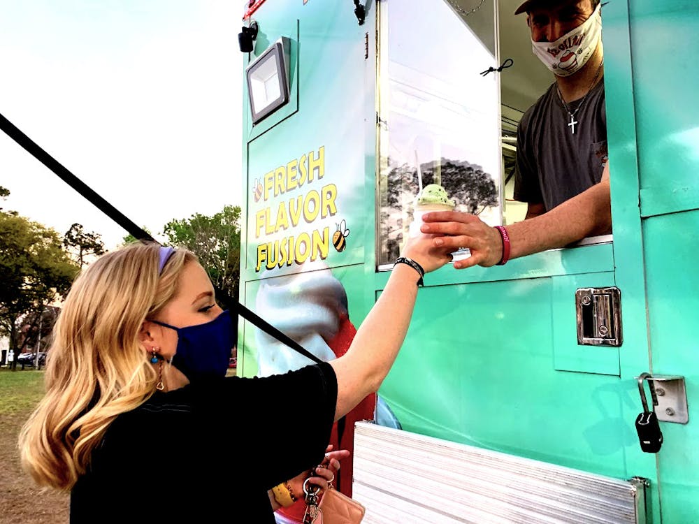 <p>Zoe Strahan, a sophomore at the University of Florida, gets her long-awaited gelati from B’z Gelati food truck at the Bonnamu Music Festival on March 12, 2021. Strahan said that if the gelati truck made more than $300 that evening, then the proceeds will go to the Children’s Miracle Network Hospitals. </p>