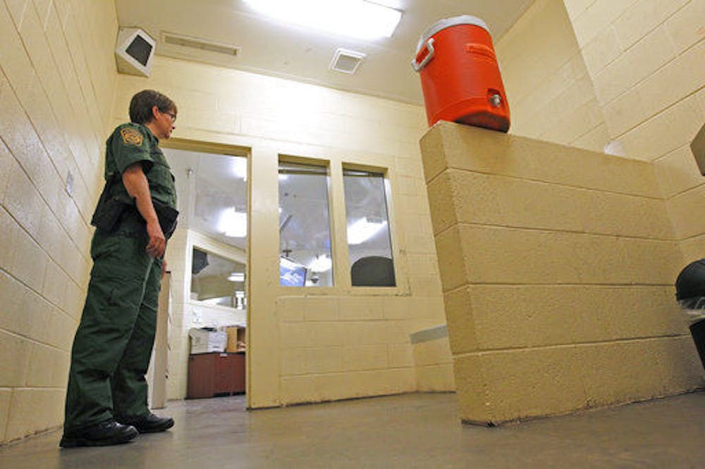 <p>In this Thursday, Aug. 9, 2012, file photo, a Border Patrol agent stands inside one of the holding areas at the Tucson Sector of the U.S. Customs and Border Protection headquarters in Tucson, Arizona.</p>