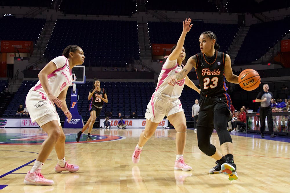 Gators senior guard Leilani Correa maintains possession of the ball while being blocked by a Razorback defender against Arkansas on Thursday, February 8, 2024.