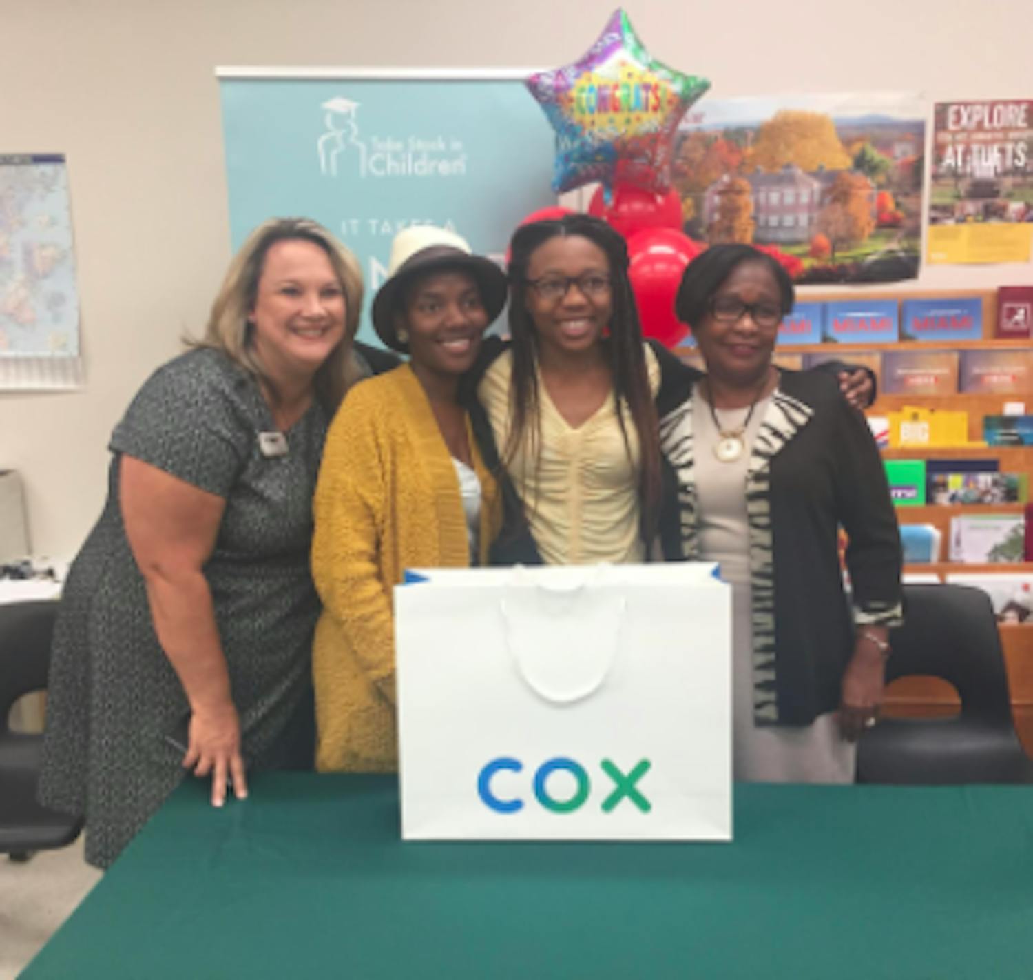 Former Superintendent Karen Clarke, left, Moore’s mom, Tedreyonce&#x27; Moore and Deputy Superintendent Donna Jones smile on Oct. 28, 2019, the day Moore received her laptop. Clarke and Jones were Moore’s mentors. (Courtesy of The Education Foundation of Alachua County)