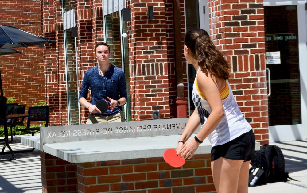 <p>Andrew Schuffer, an 18-year-old neurobiological sciences freshman, plays ping pong outside Newell Hall Tuesday afternoon with Ariana Johnson, a 19-year-old microbiology and cell science freshman as part of the Newell Hall Block Party which marked the one year anniversary of the building's reopening.</p>