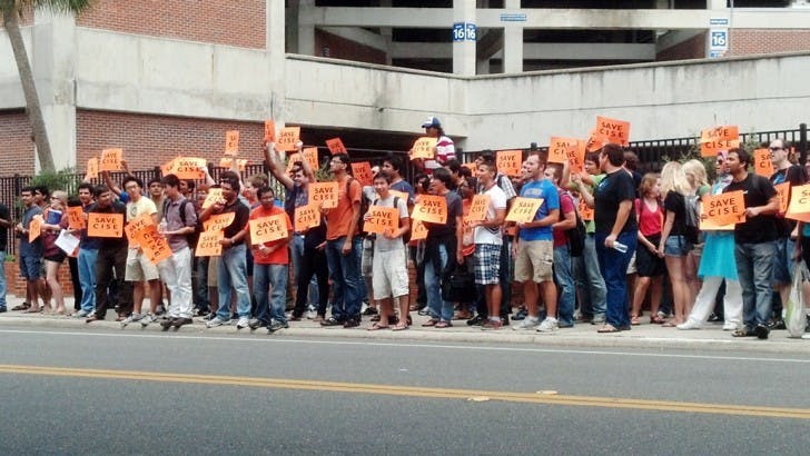 Students hold signs that read “Save CISE” on Stadium Road across from Weil Hall during a protest against budget cuts on Monday afternoon.