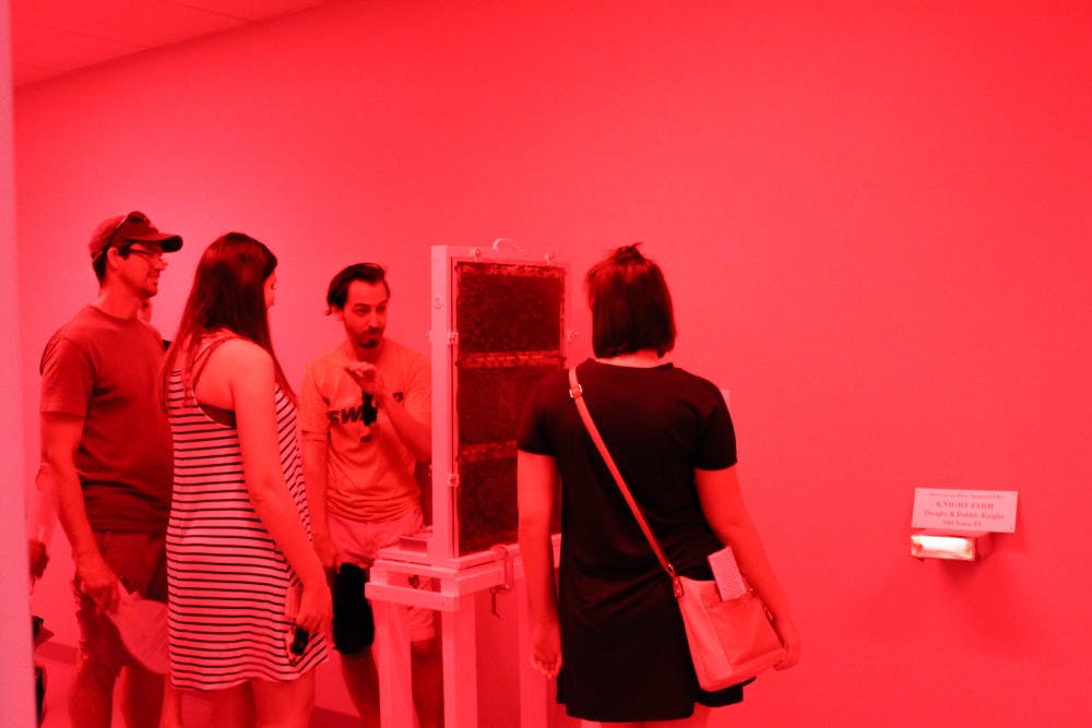 Onlookers watch bees work in awe Saturday in the Observation Room at the Honey Bee Lab’s grand opening. At the event, artifacts are on put on display from age-old beekeeping methods. The Honey Bee Lab is located at 1881 Natural Area Drive.