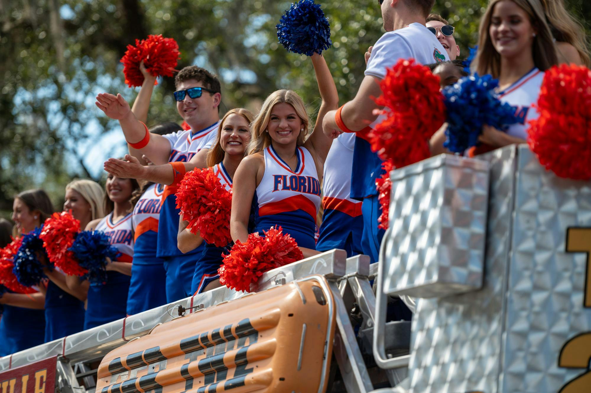 UF cheerleaders ride stop a Gainesville Fire Engine down 13th Street in the 102nd UF Homecoming Parade. The parade took place on Friday, Oct. 17, 2025.