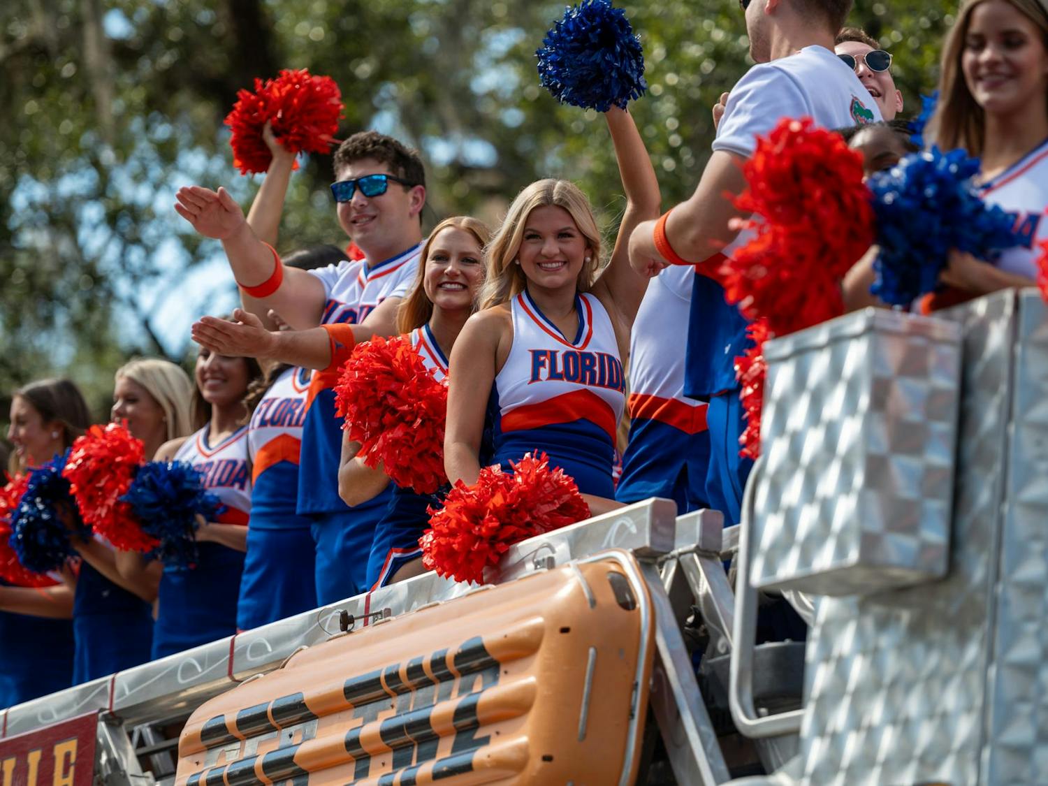 UF cheerleaders ride stop a Gainesville Fire Engine down 13th Street in the 102nd UF Homecoming Parade. The parade took place on Friday, Oct. 17, 2025.