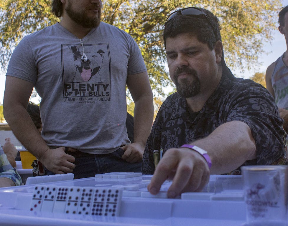 Juan Martinez, a 49-year-old Gainesville resident, plays dominoes Saturday during the Mi Apa Domino Tournament and Elio Piedra Conga Drum Ensemble at Mi Apa Latin Cafe, 114 SW 34th St. More than 50 people participated in this event.