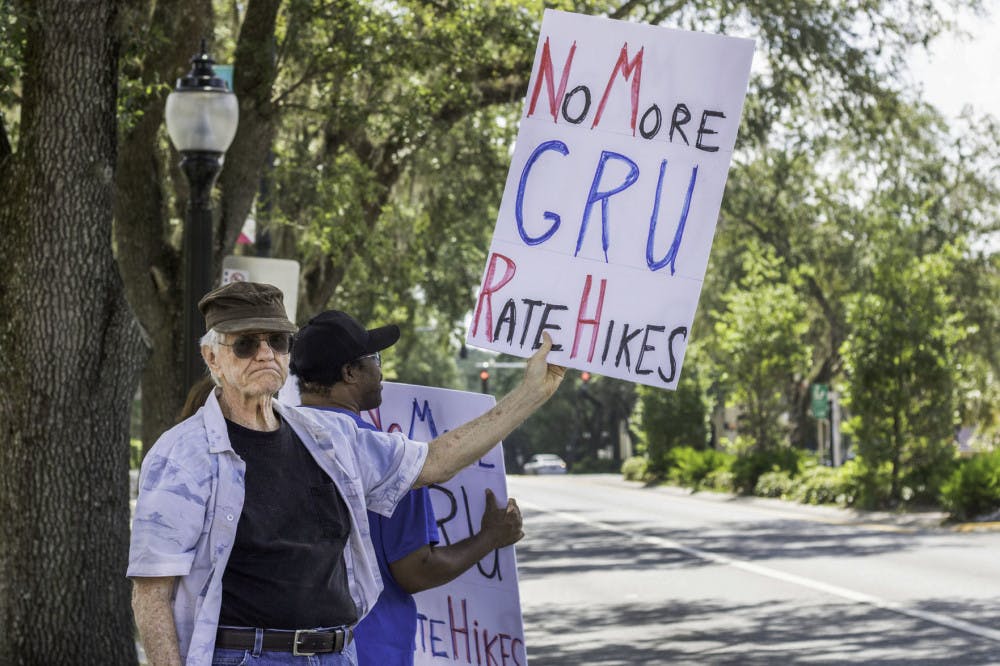 <p><span id="docs-internal-guid-e0bc17e7-7fff-cb75-76e4-0135477fd8d0"><span>Harold Saive, 75, holds up a protest sign while Jason Davis, 46, stands behind him noon Thursday along University Avenue outside of City Hall. Saive said he believes that most people support the cause but are too timid to protest in person. “For every person who shows up here there’s a thousand behind them who agree,” Saive said.</span></span></p>