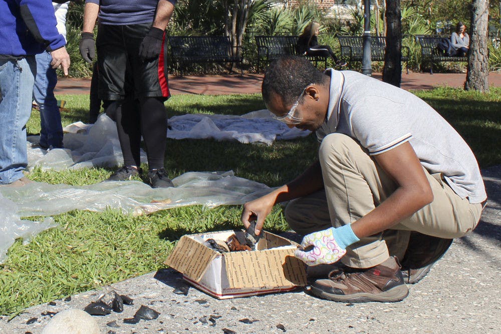 <p>Abebe Taffere, a 35-year-old UF first-year archaeology graduate student, sifts through a box of stones, which he used to construct a tool. Taffere is a member of “UF and Ethiopia,” a course that is sending 10 students to an archaeological excavation in Ethiopia.</p>