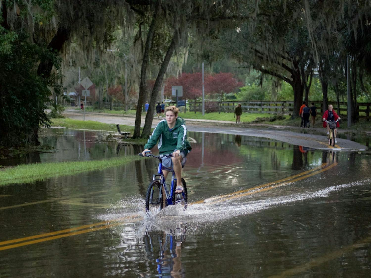Students ride their bicycles through nearly a foot of water on the streets near Lake Alice. Lake Alice is one of the areas that flooded on campus during Hurricane Irma.