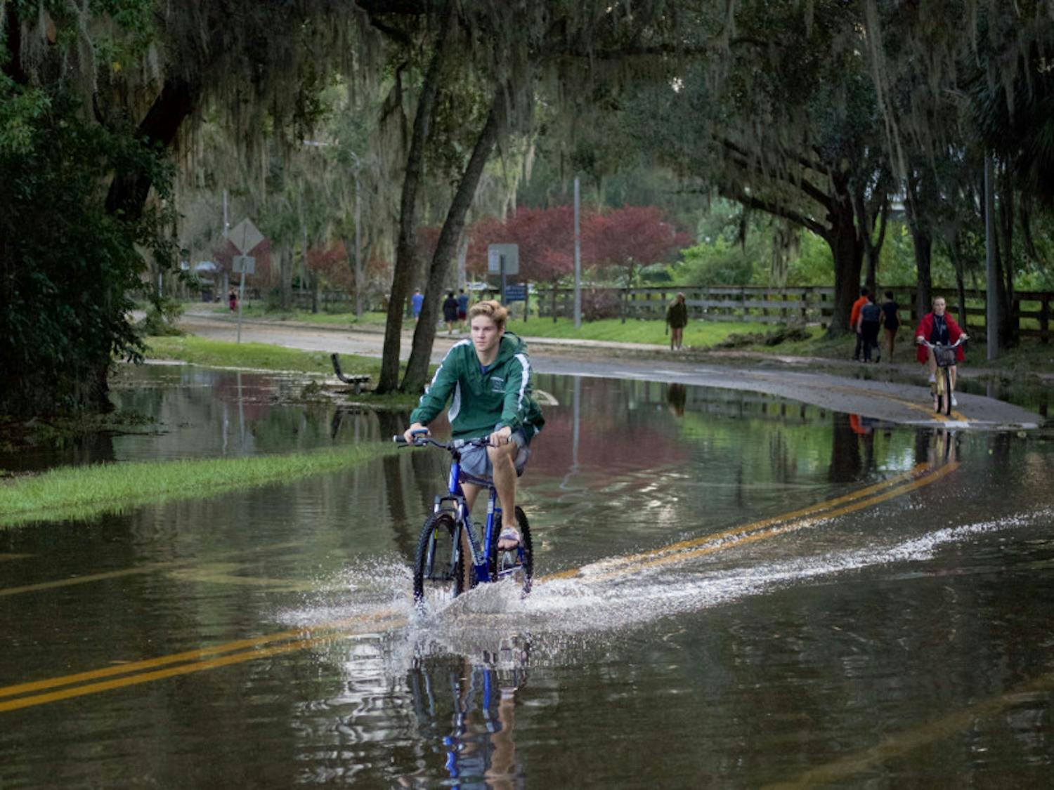 Students ride their bicycles through nearly a foot of water on the streets near Lake Alice. Lake Alice is one of the areas that flooded on campus during Hurricane Irma.