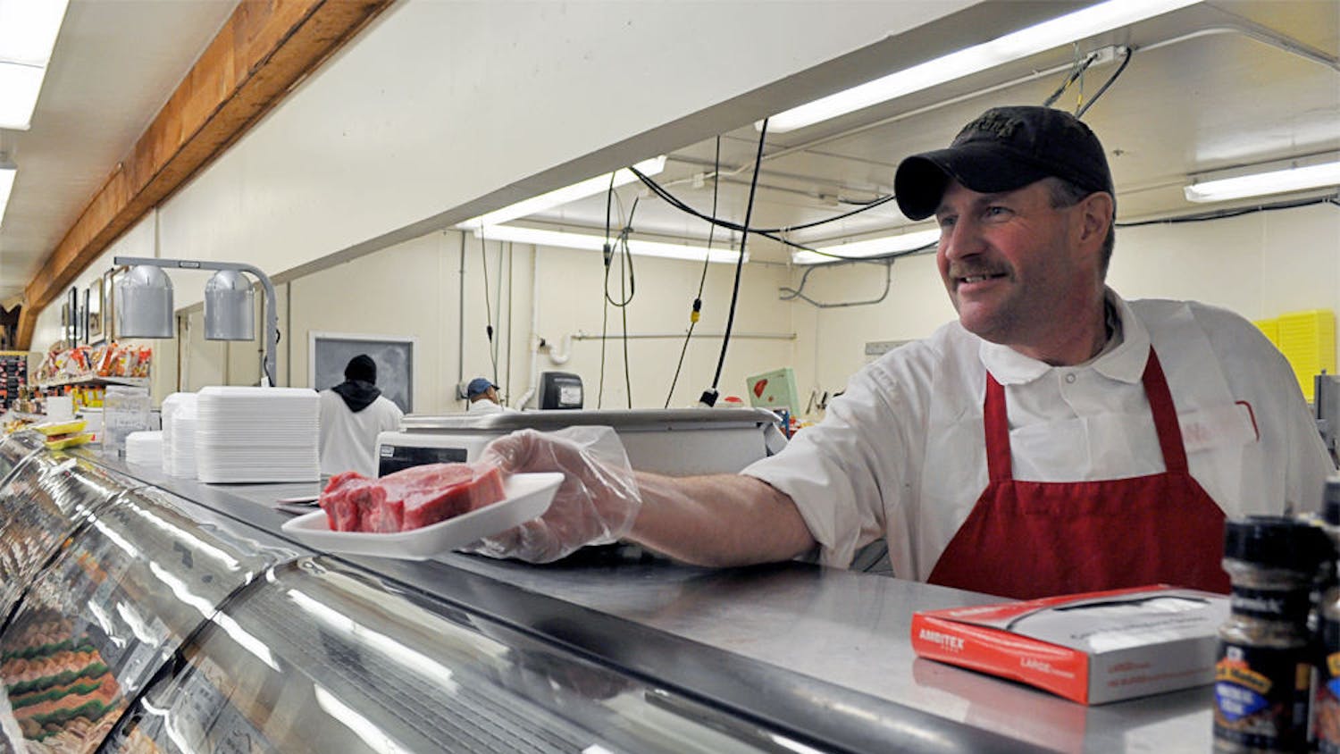 David Farrell, 48, displays a steak to a Ward's Supermarket customer on Tuesday.