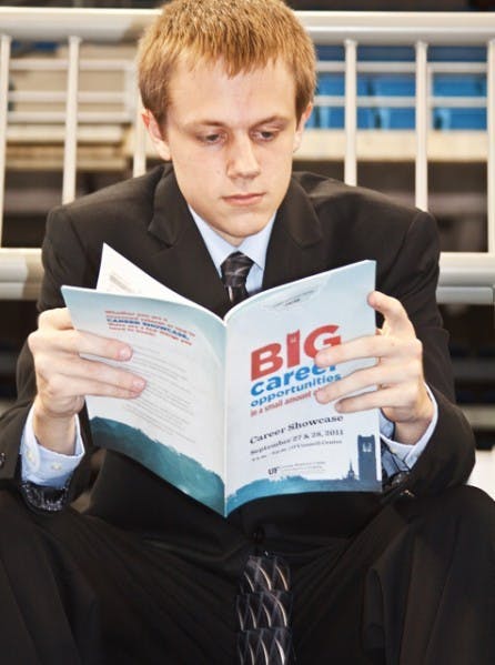 Accounting student Jonas Wilken, 19, takes a break from the exhausting interviewing process at the Career Showcase in the Stephen C. O'Connell Center Tuesday to check out which corporation he might like to visit next.