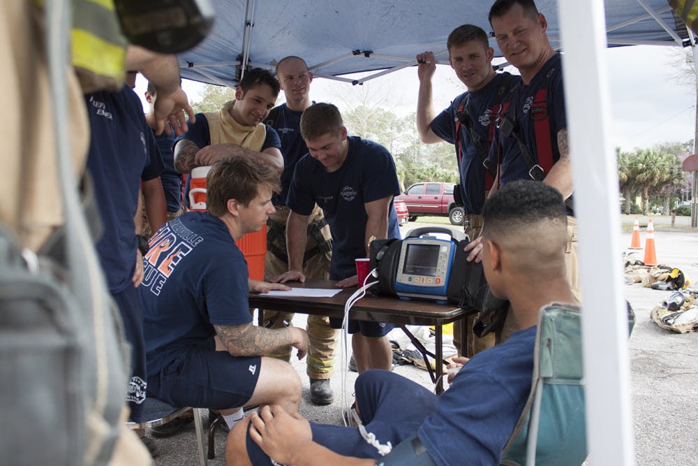 The new hires check each other's vital signs before heading into burning shipping containers for live-burn training at Gainesville Fire Rescue Station 3, located at 900 NE Waldo Rd. 