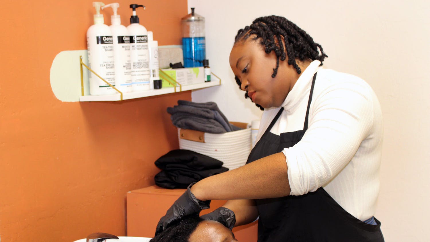 Denisha Williamson-Walker shampooes a client's hair at her Locs by Dee salon located at 4040 W Newberry Road Unit 1300 on Friday, Jan. 28.